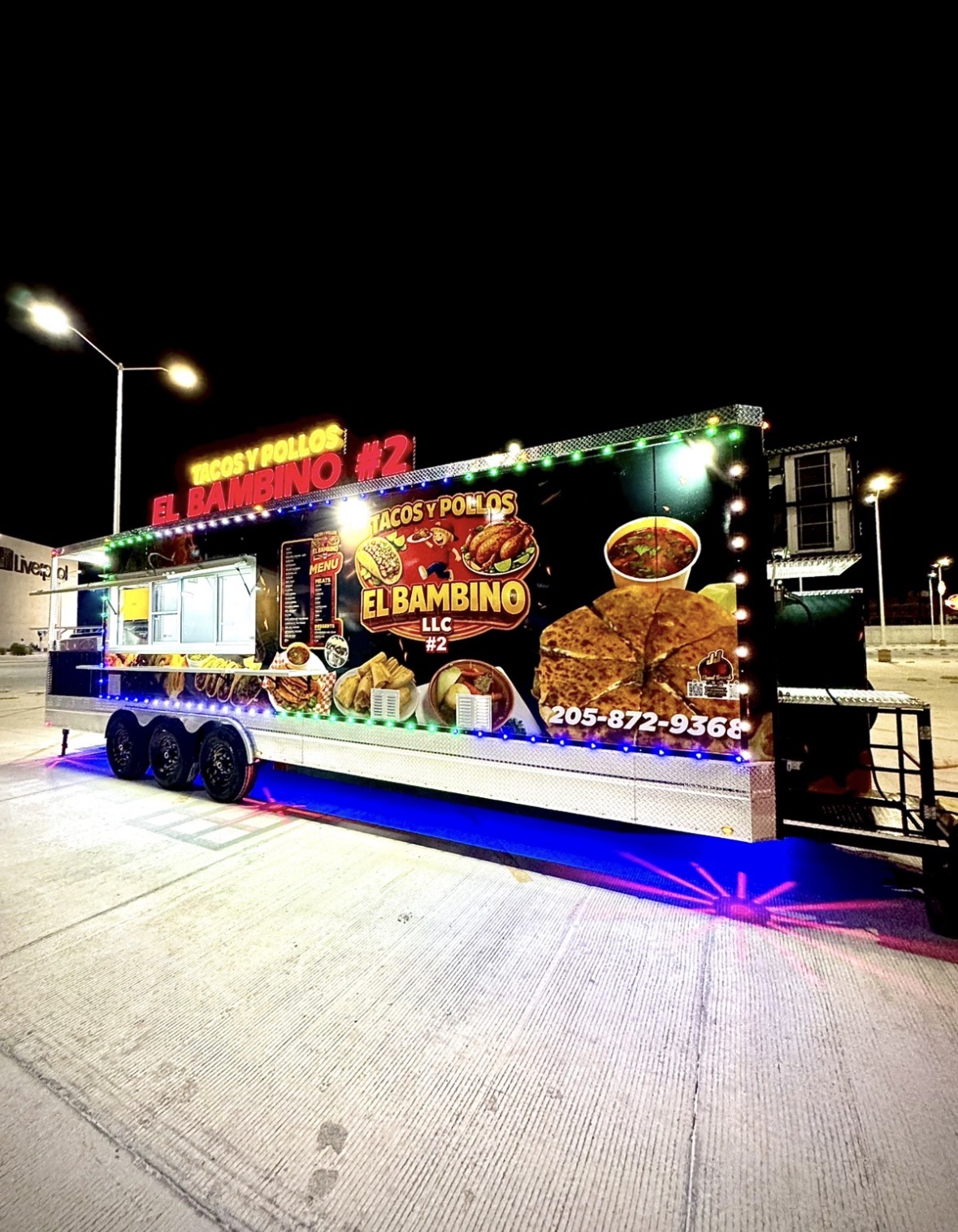 Tacos y Pollos El Bambino #2 concession trailer lit up at night