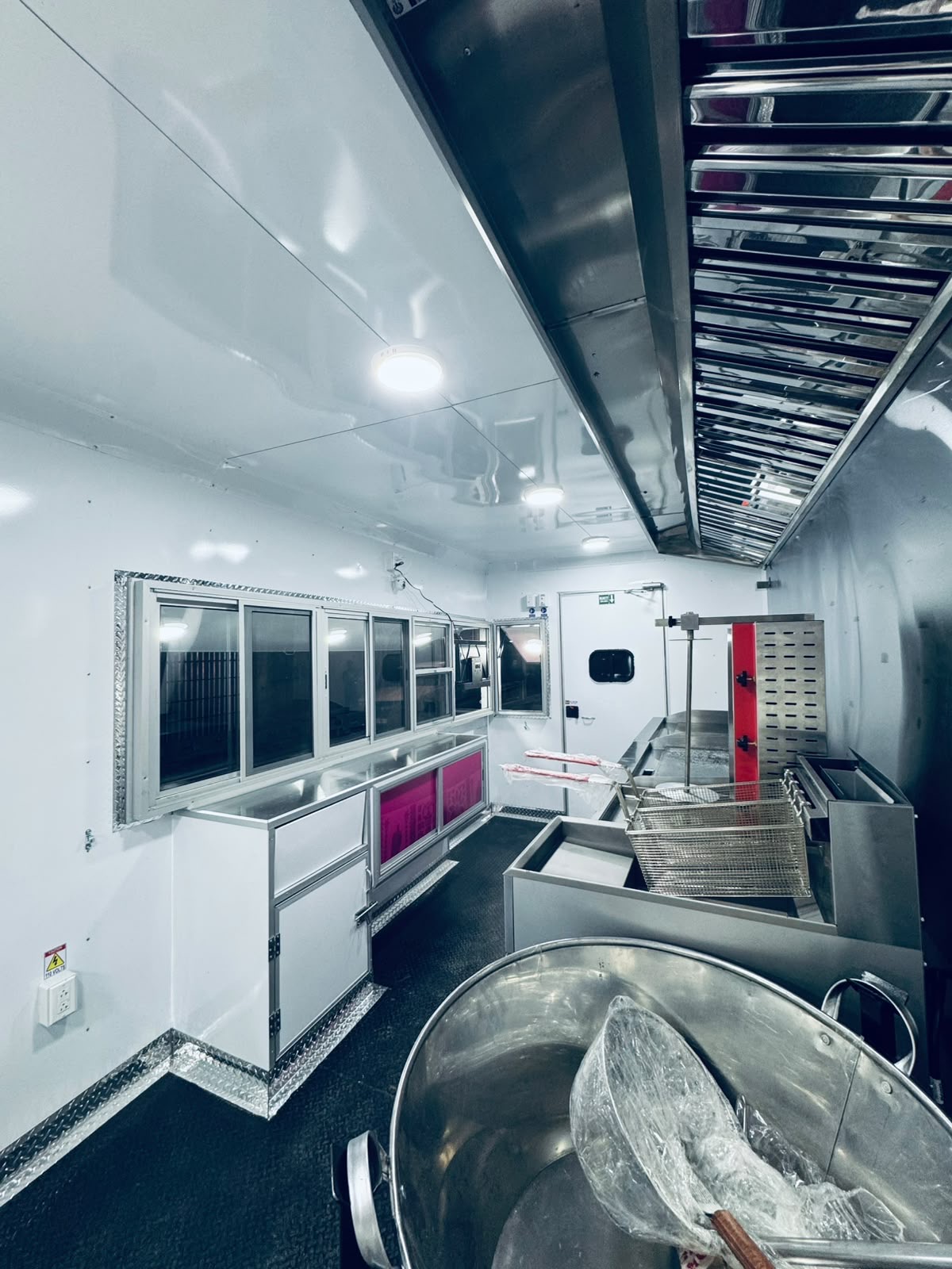 Interior of a food trailer with serving windows and prep area